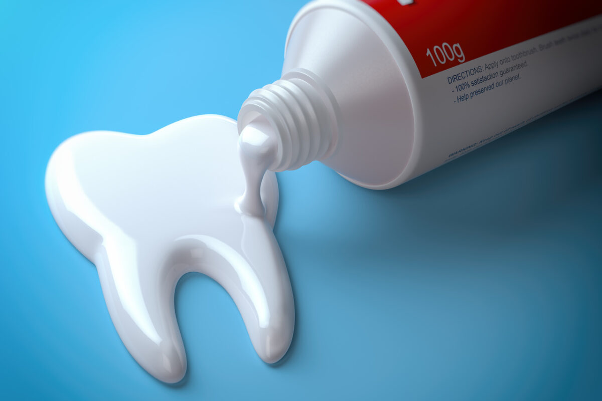 Toothpaste in the shape of tooth coming out from toothpaste tube