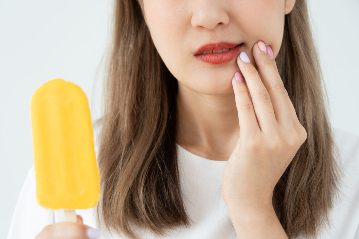 Asian woman feel sensitive teeth after eating ice cream, female suffer tooth, decay problems, dental care, tooth extraction, decay problem, bad breath, Gingival Recession, Oral Hygiene instruction